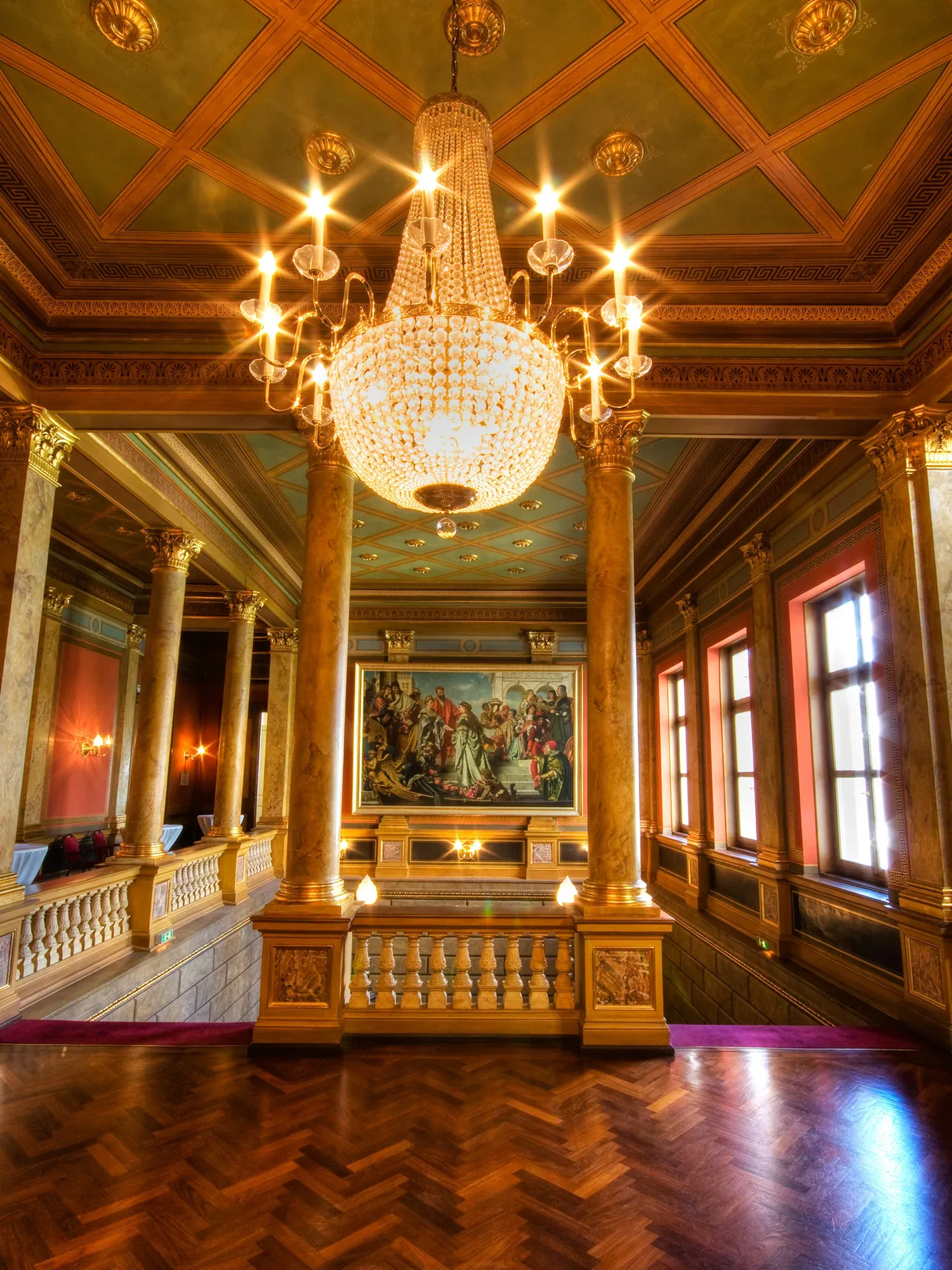 Eleganter Saal der Casino-Gesellschaft Wiesbaden mit prunkvollem Kronleuchter und historischen Gemälden, ideal für Hochzeiten und festliche Anlässe.