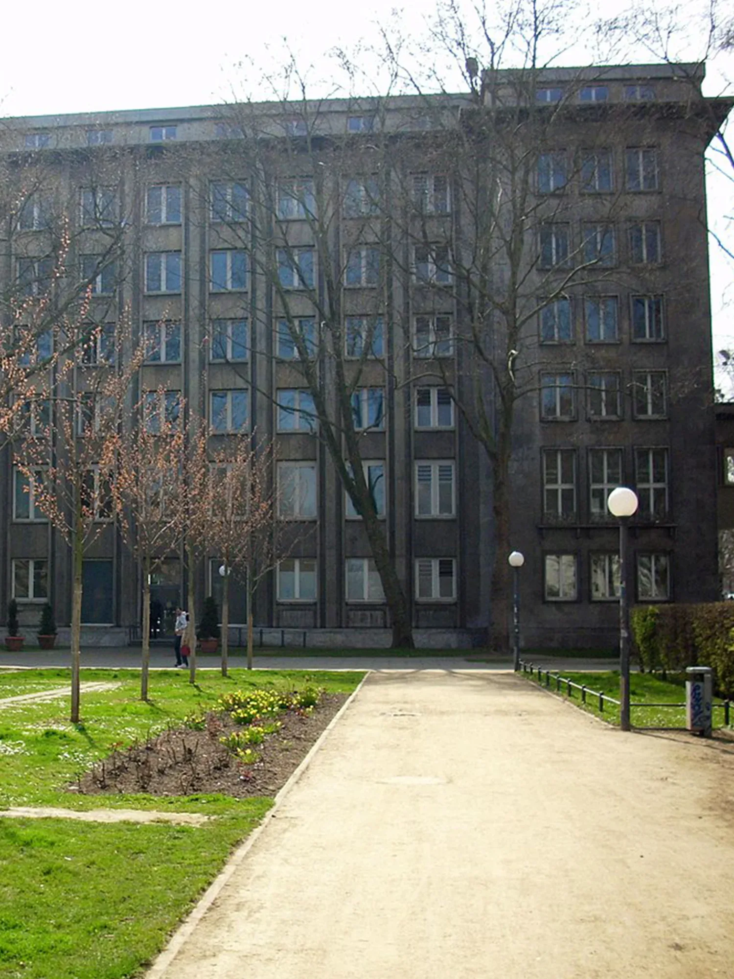 Modernes Stadthaus mit schlichten Fassaden und weitläufigem Vorplatz, umgeben von Bäumen, bietet einen neutralen Ort für standesamtliche Trauungen.