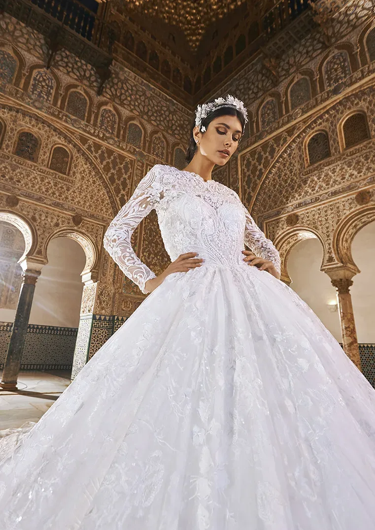 Luxuriöses Brautkleid mit Spitzenmuster und hohem Kragen, getragen in einer prächtigen, historischen Kulisse mit aufwendigen Verzierungen.