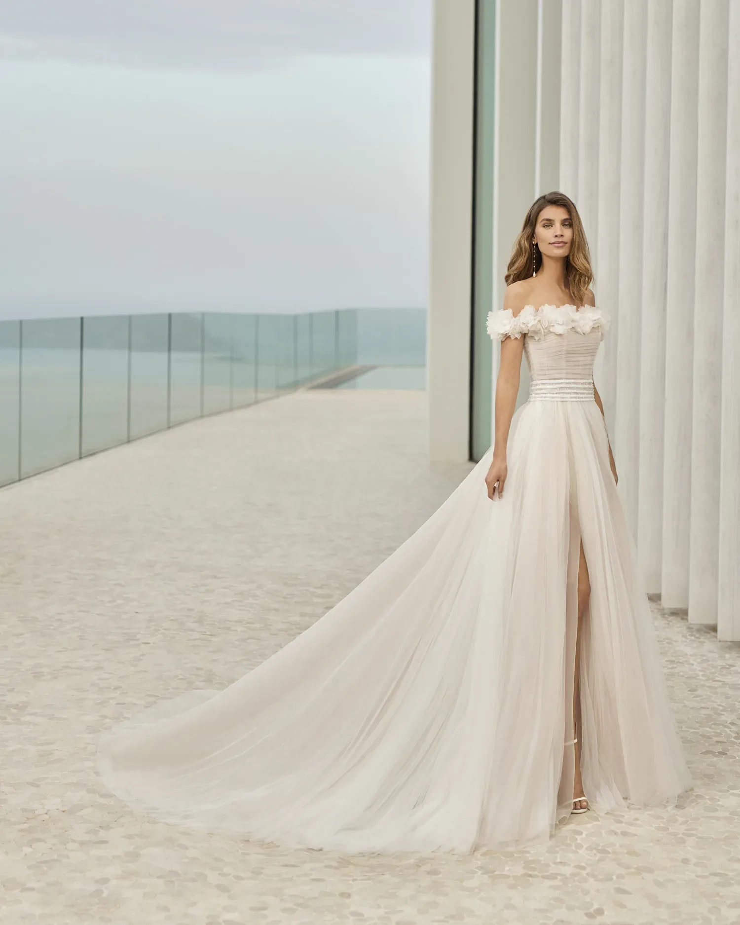 Atemberaubendes Brautkleid im Off-Shoulder-Stil mit herzförmigem Ausschnitt und einer fließenden Tüllschicht, die die Silhouette umspielt.