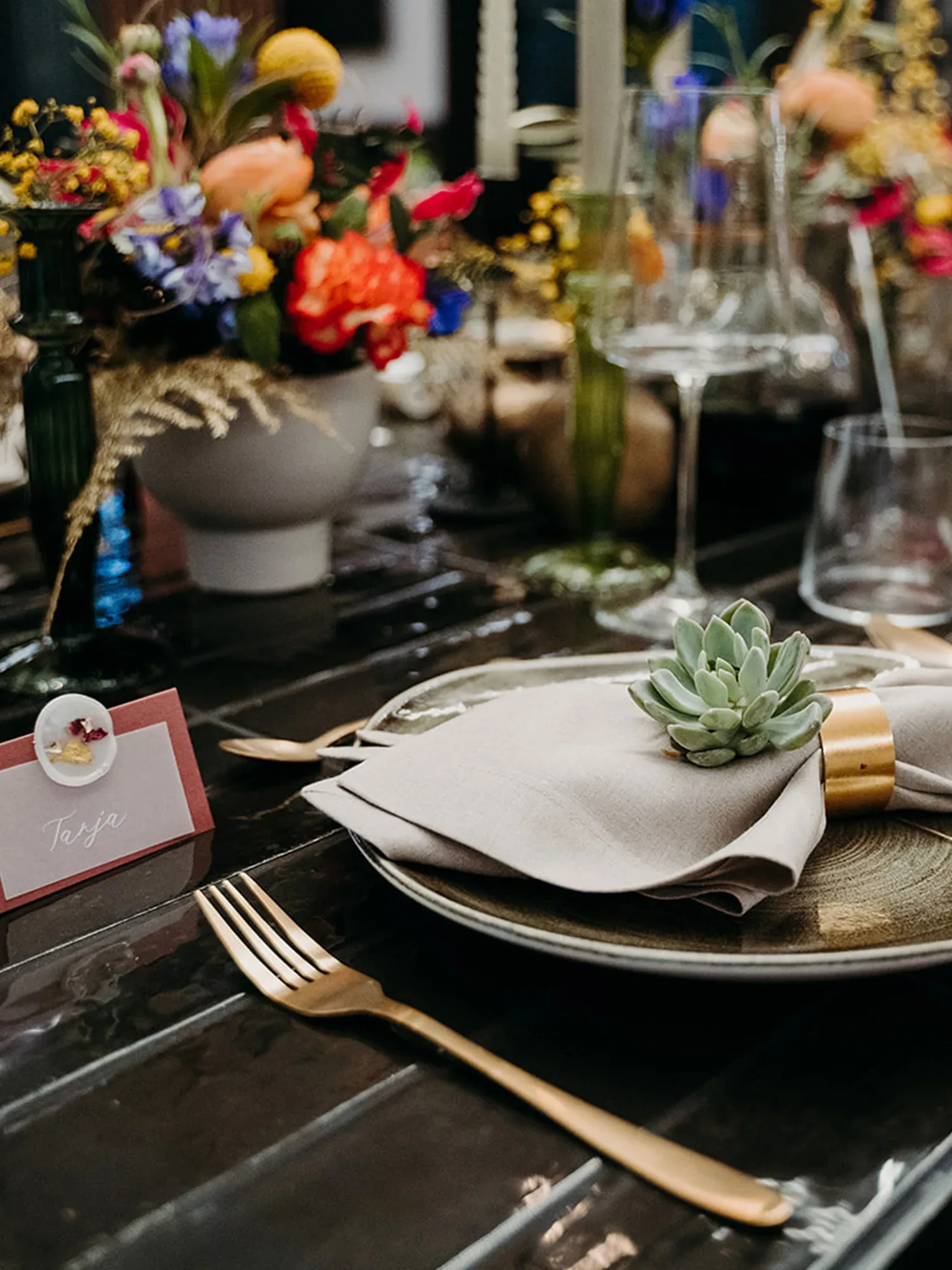 Table Setting bei einer Hochzeit mit bunten Blumen und Steingewächs