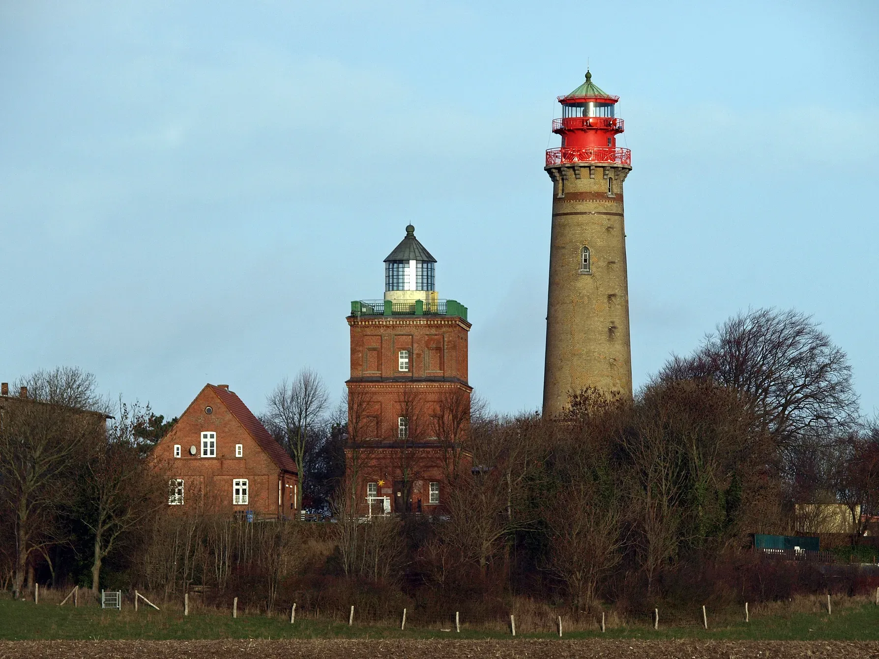 Die berühmten Leuchttürme von Kap Arkona auf Rügen, umgeben von Bäumen und Wiesen, an einem klaren Tag.