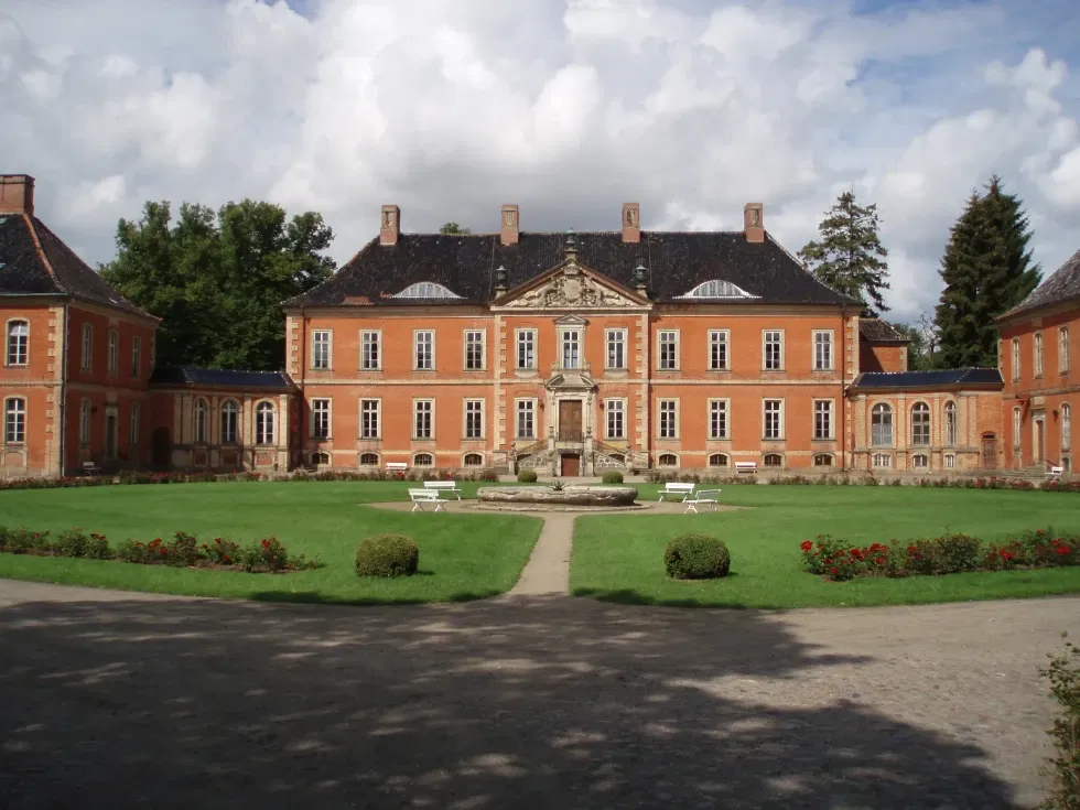 Die imposante Außenansicht von Schloss Bothmer, umgeben von gepflegten Gärten. Das historische Gebäude besticht durch seine barocke Architektur.