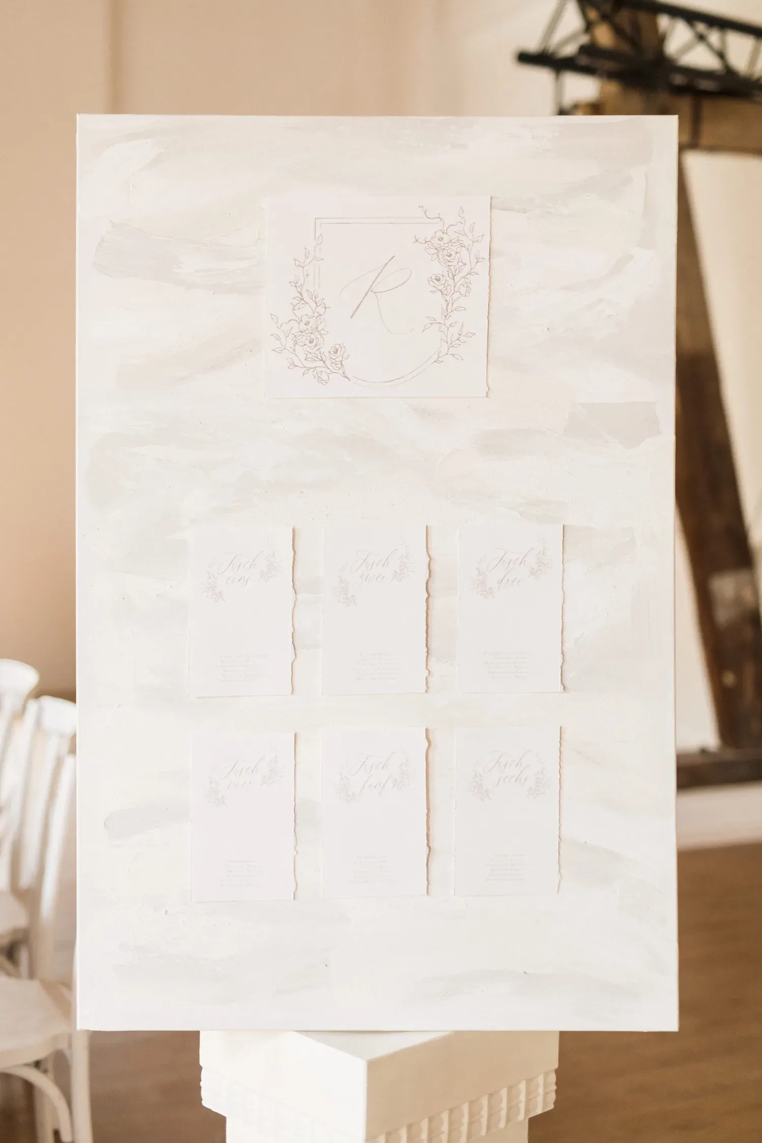 Eine stilvoll gestaltete Sitzordnungstafel in sanften Weißtönen mit floralen Akzenten, passend für eine elegante Hochzeit.