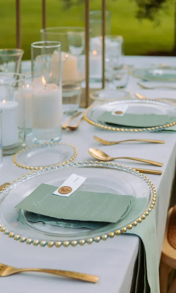 Festliche Tafel für eine Hochzeit mit Kerzen und goldenem Besteck.