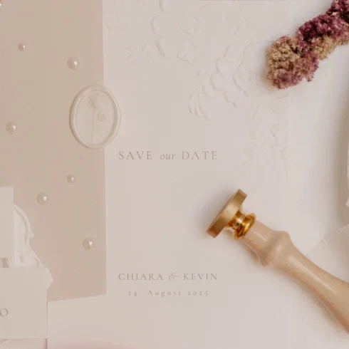 Minimalistische Save-the-Date-Karte von Chiara & Kevin mit Datum, ergänzt durch Wachssiegel, Blüten und edlen Siegelstempel in warmen Nude-Nuancen.