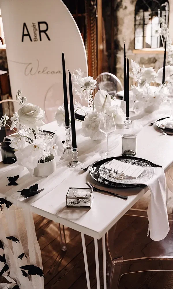 Table Setting mit schwarzen Kerzen und weißen Blumen