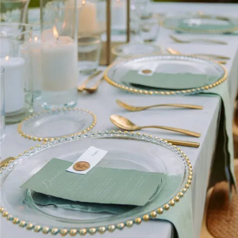 Festliche Tafel für eine Hochzeit mit Kerzen und goldenem Besteck.