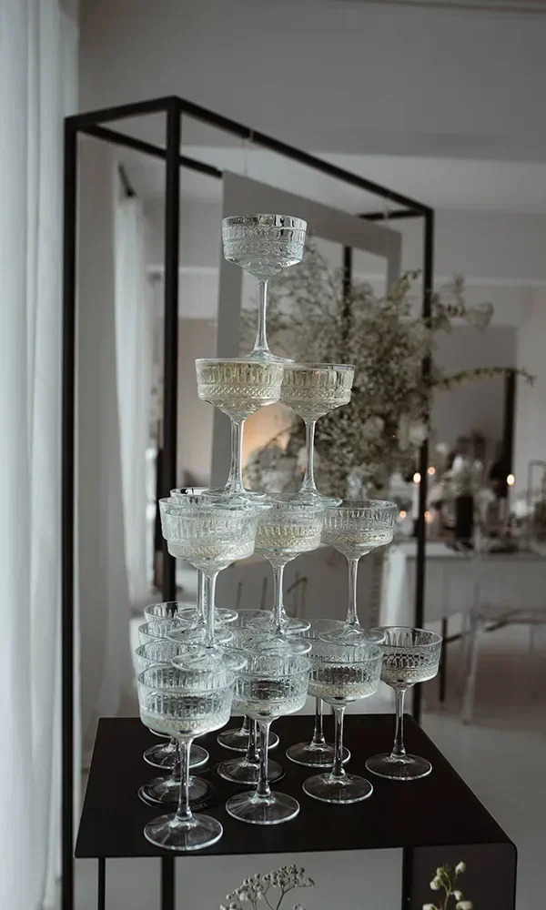 Eleganter Champagner-Turm aus gestapelten Gläsern bei einer Hochzeit im Black & White-Thema