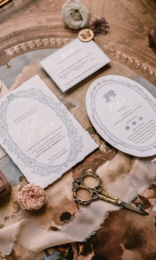 Luxuriöse Hochzeitseinladungen und Papeterie mit Kalligrafie und Blumenmotiven auf einem eleganten Hintergrund