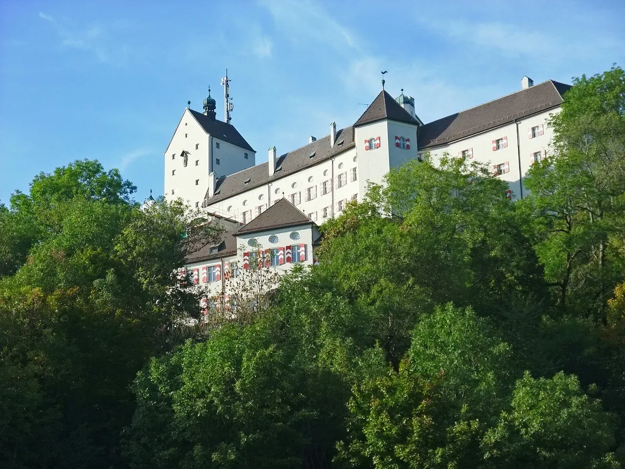 Das Schloss Hohenaschau, im Vordergrund sind ein paar Bäume zu sehen.
