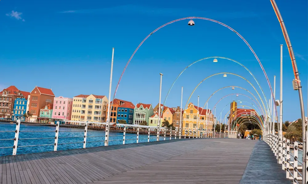 Blick von einer Promenade auf bunte Häuser am Kai.