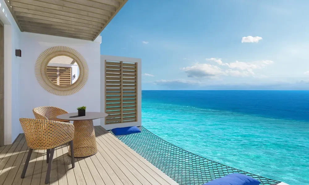 Hotelzimmer mit Terasse mit Ausblick auf das türkise Meer.