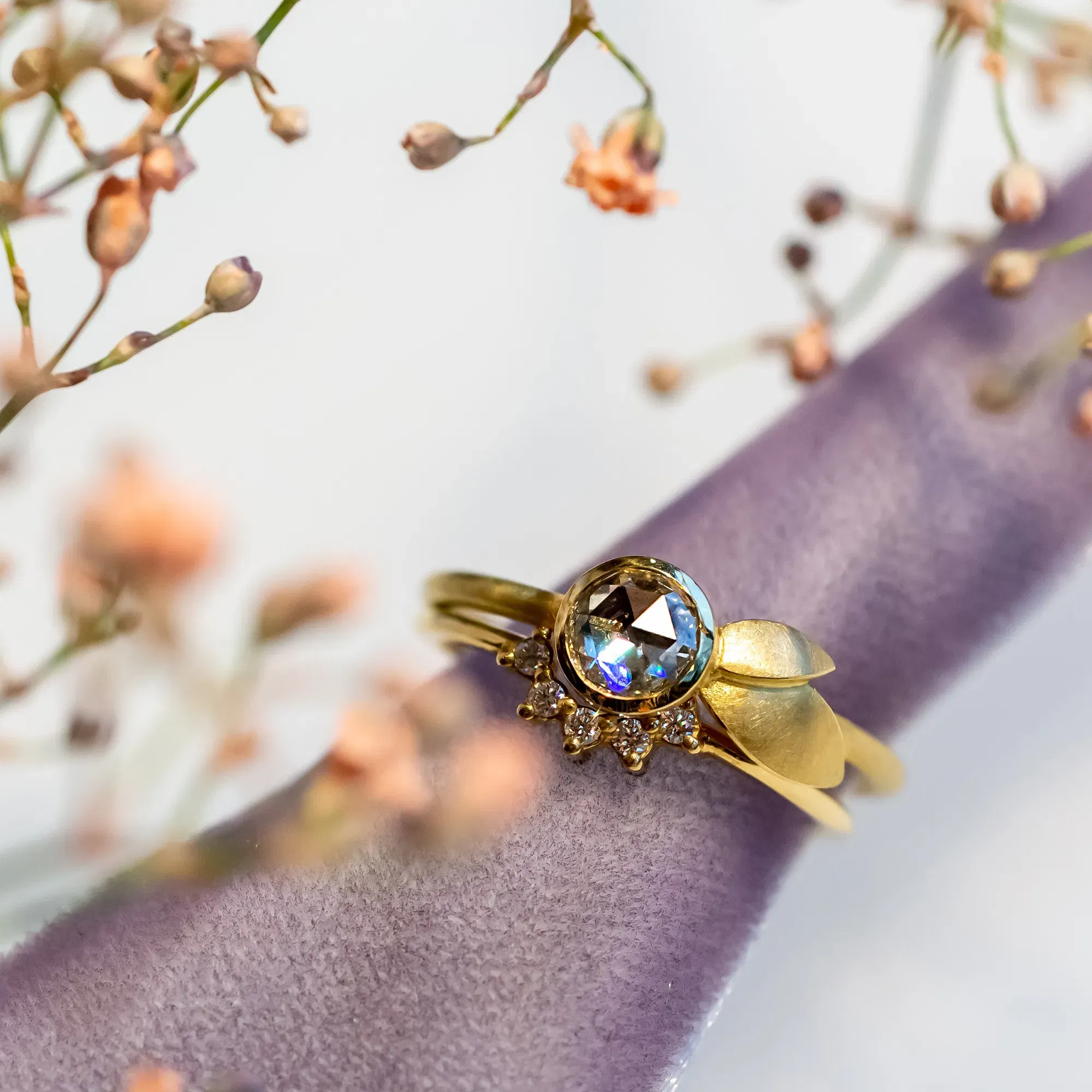 Üppiger Ring drappiert in einem lilafarbenem Tuch.