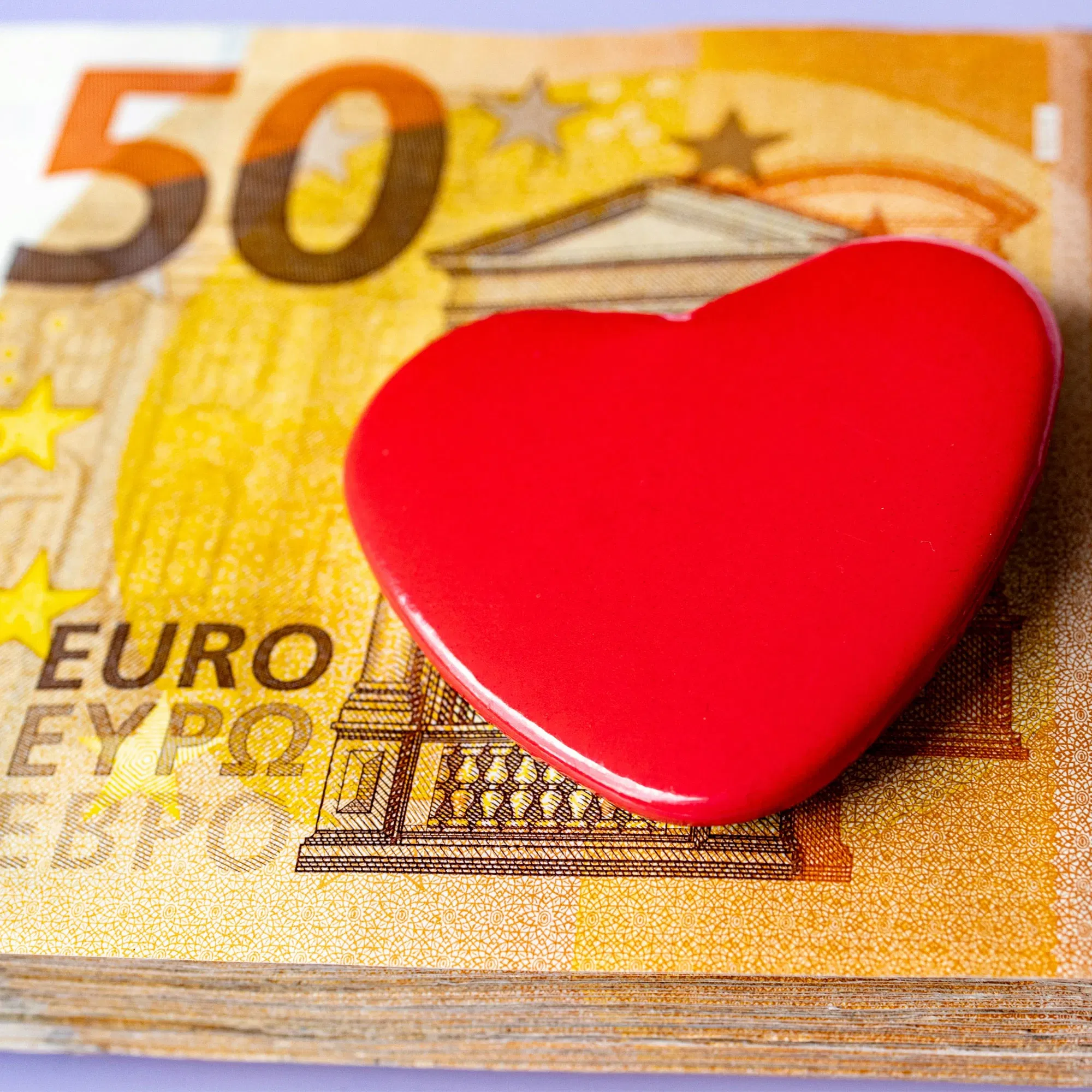 Ein Stapel 50-Euro-Scheine mit einem roten Herz darauf, symbolisiert ein liebevoll gestaltetes Geldgeschenk für besondere Anlässe wie Hochzeiten oder Jubiläen.
