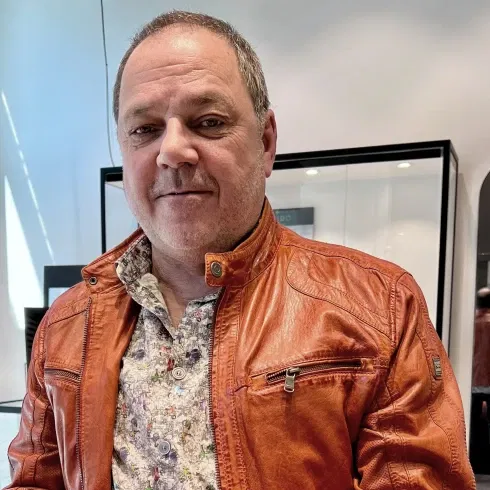 Porträt von Ingo Adam, Inhaber der Goldschmiede Adam, in einer markanten Lederjacke, aufgenommen in seinem Geschäft in Hagen.