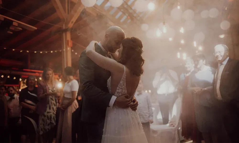 Inniger Hochzeitstanz des Brautpaars in festlich geschmückter Scheune.