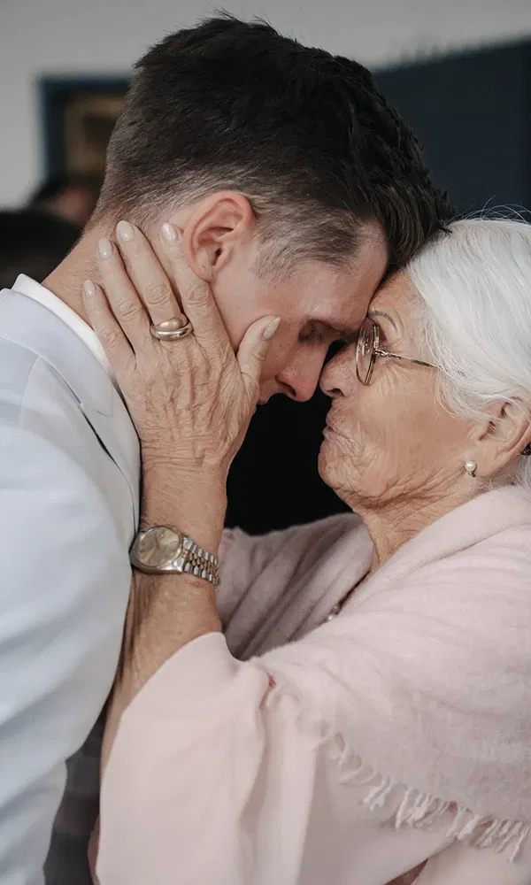 Emotionale Umarmung zwischen Großmutter und Bräutigam.