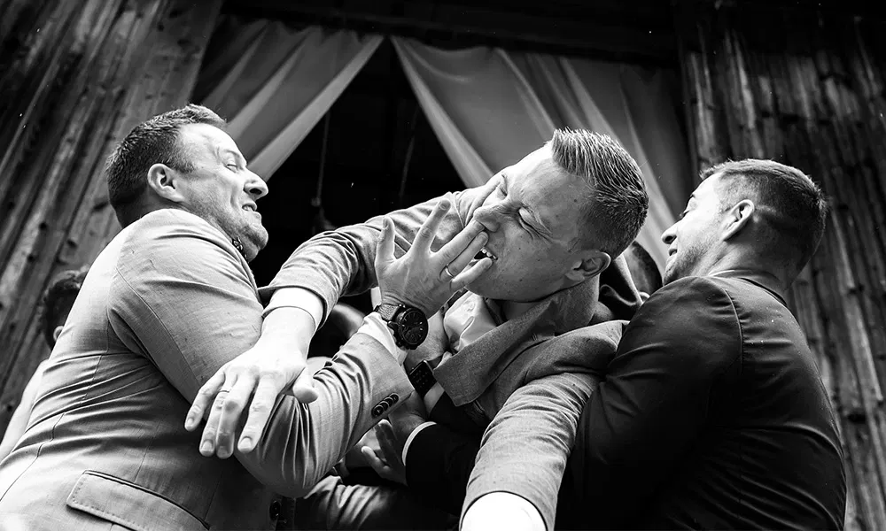 Freunde des Bräutigams toben scherzhaft beim Fotoshooting.