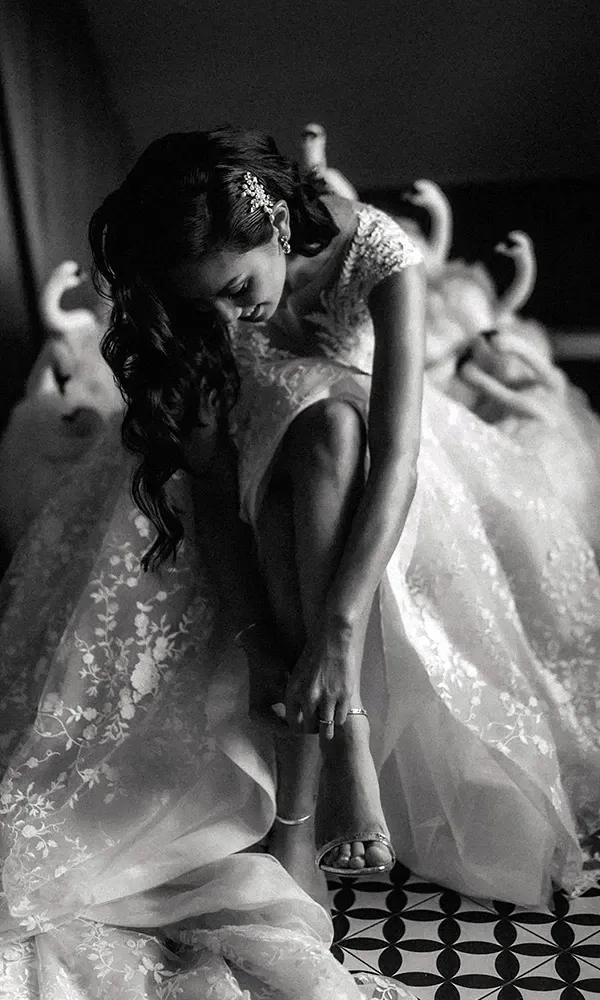 Schwarz-weiß-Moment: Braut legt ihre Hochzeitsschuhe an.