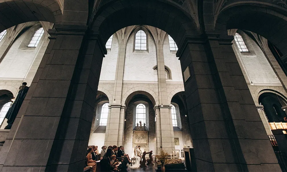 Majestätische Perspektive einer kirchlichen Trauung mit Blick auf das Brautpaar am Altar.