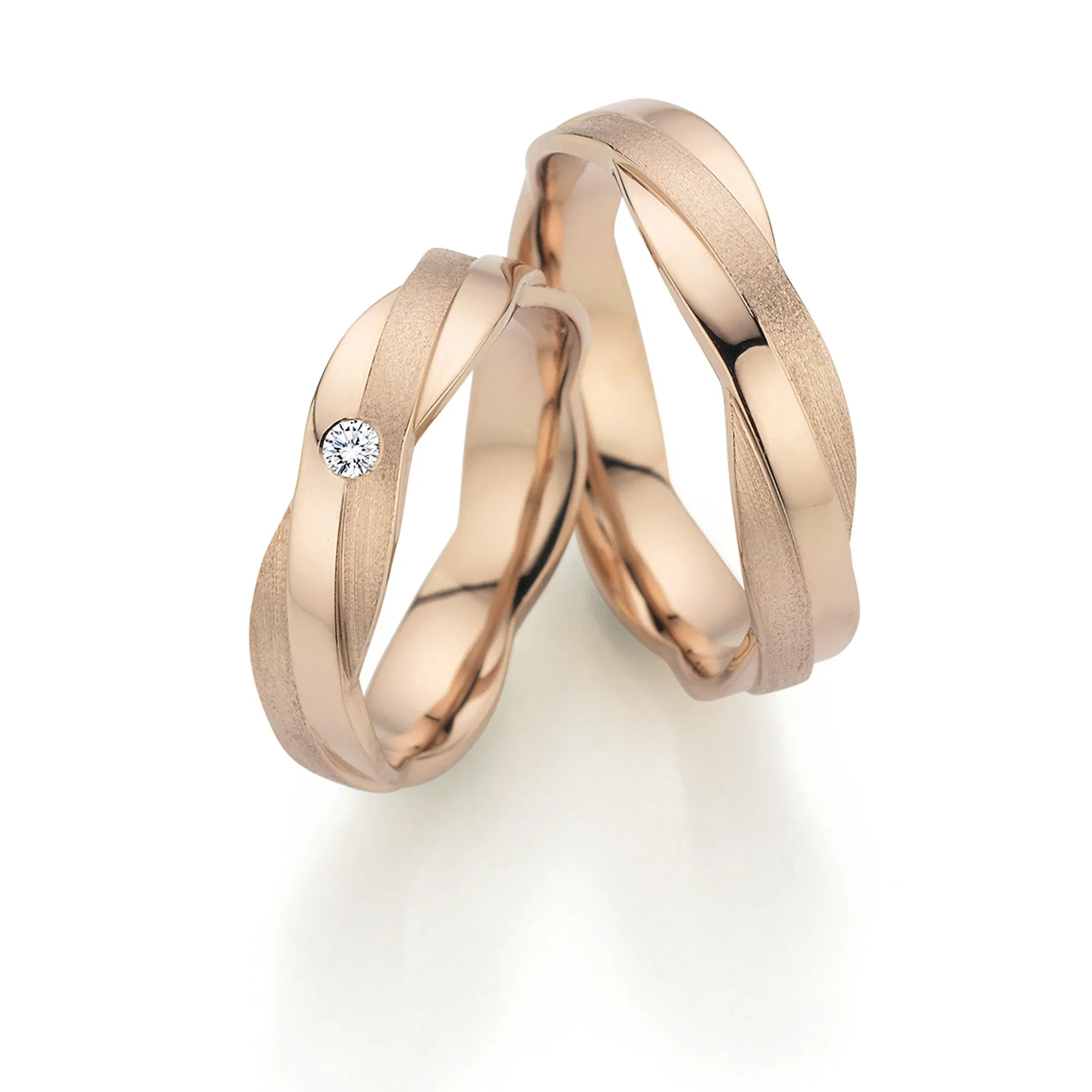 Alt 1: Roségoldene Trauringe mit ineinander verschlungenem Design und einem einzelnen Brillanten.