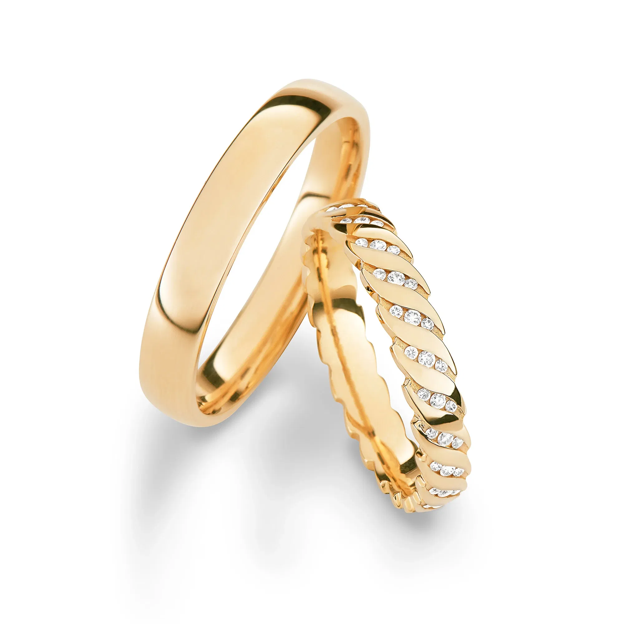 Verspielter Damenring mit filigranem Design und Brillantakzenten, kombiniert mit schlichtem Herrenring.