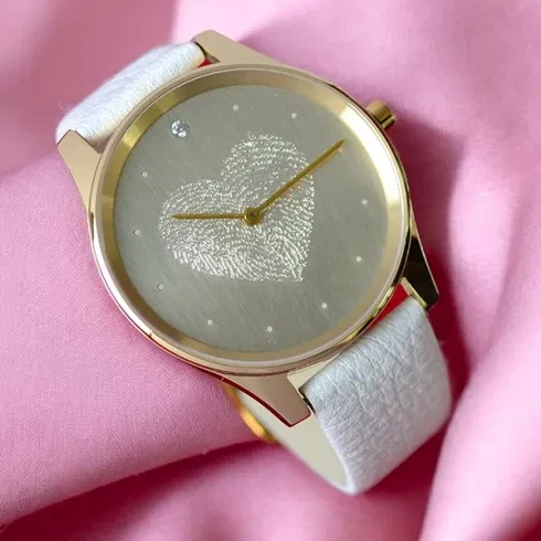 Eine Uhr von Vater& Sohn mit weißem Armband und Fingerabdruck in herzform im Ziffernblatt