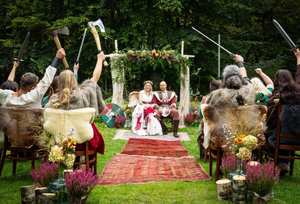 Freie Trauung im Wikinger Stil im Wald mit Schwertspalier, Fellstühlen und floraler Dekoration