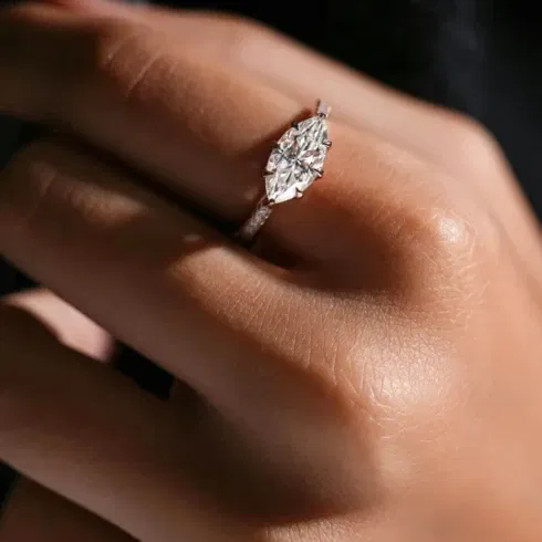 Eleganter Verlobungsring mit marquiseförmigem Diamanten an einer Hand in Nahaufnahme.