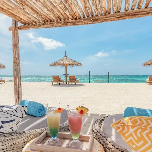 Entspannter Strandtag während der Flitterwochen auf den Malediven – Cocktails unter Palmen im Luxusresort