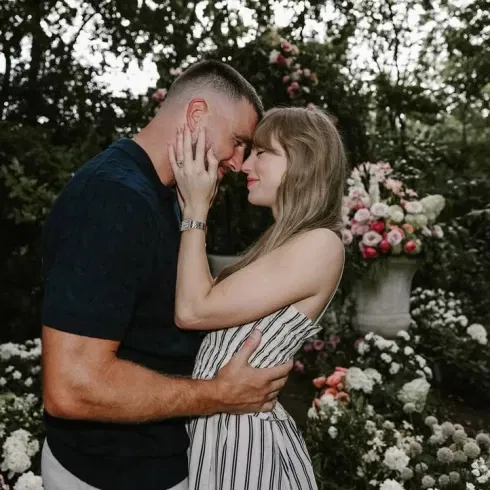 Taylor Swift und Travis Kelce halten sich verliebt im Arm und blicken einander tief in die Augen.