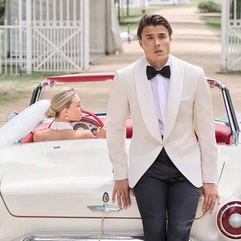 Bräutigam im cremefarbenen Dinner Jacket mit Fliege – eleganter Gentlemanlook und moderne Bräutigamfashion für die Hochzeit.