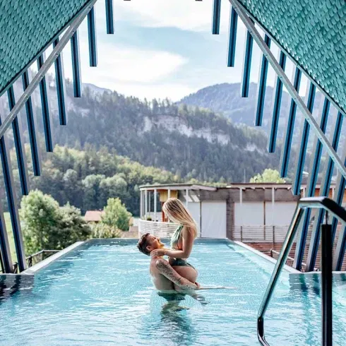 Romantischer Moment im Sky-Pool des Hotels GAMS in Bezau – Paar genießt Wellness mit Blick auf die Berge.