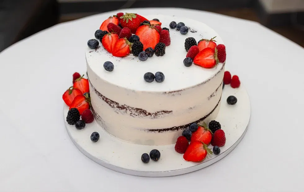 Eine weiße Torte mit Beerenverzierungen