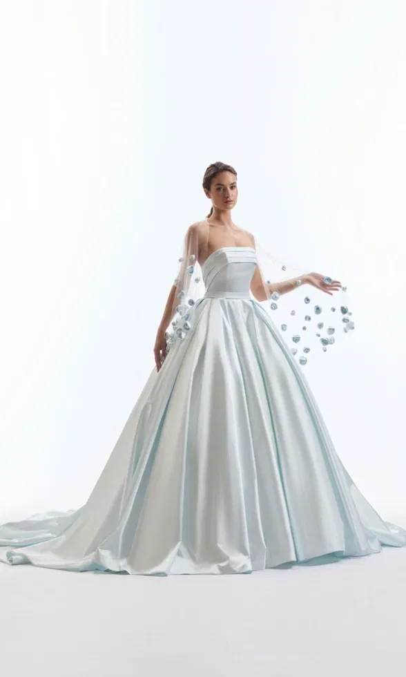 Auffälliges Ballkleid in hellem Eisblau mit weitem Rock und transparentem Cape, verziert mit schimmernden 3D-Blüten.