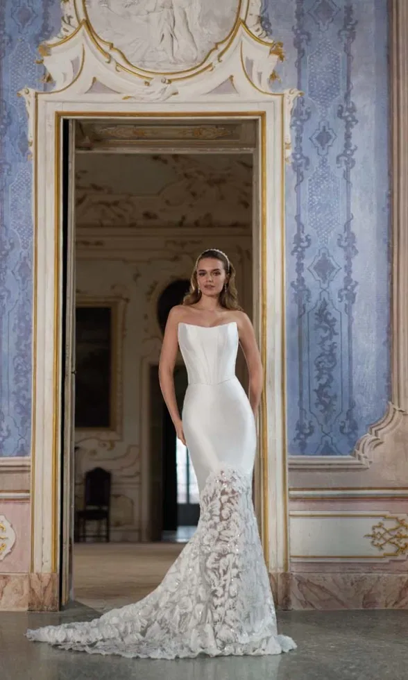 Schmales, trägerloses Brautkleid mit strukturierter Korsage und Spitze im Fishtail-Stil, aufgenommen im Schlossambiente.