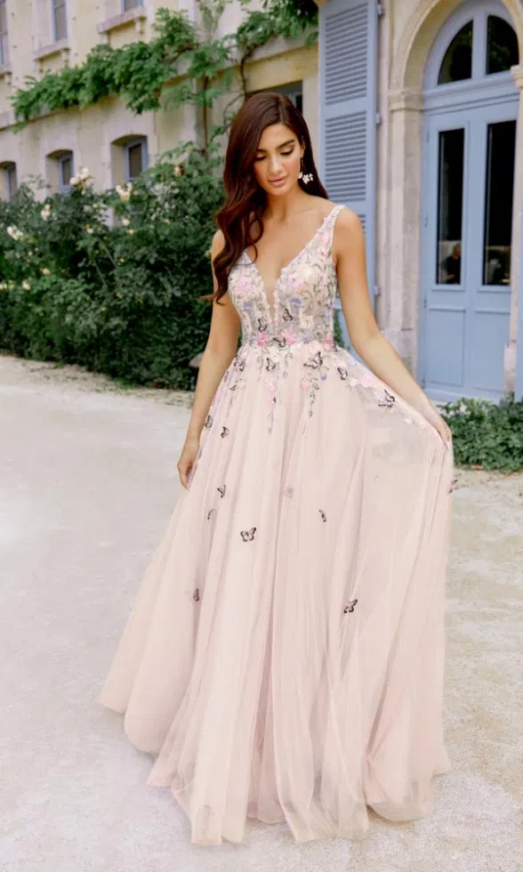 Romantisches Blush-Brautkleid mit floral besticktem Oberteil und Tüllrock, fotografiert vor einem französischen Herrenhaus.