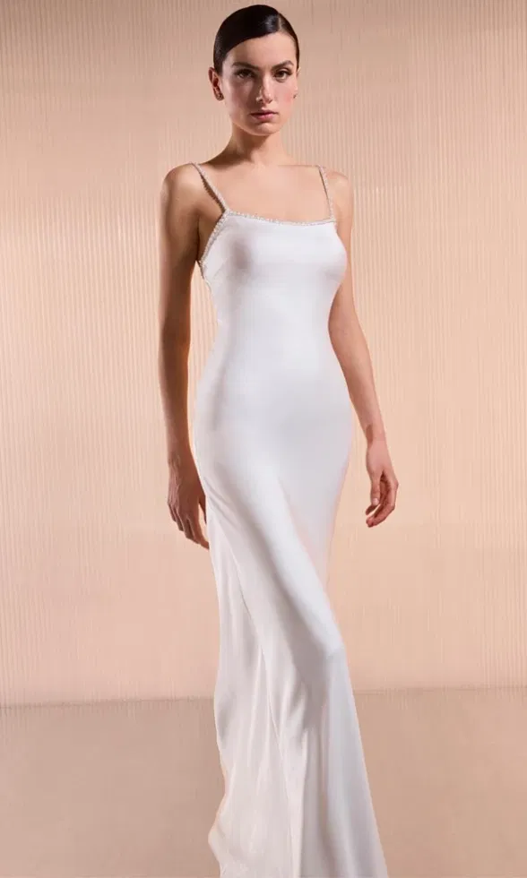 Schlankes Slip-Dress mit Perlenverzierung an den Trägern in minimalistischem Studio-Setting.