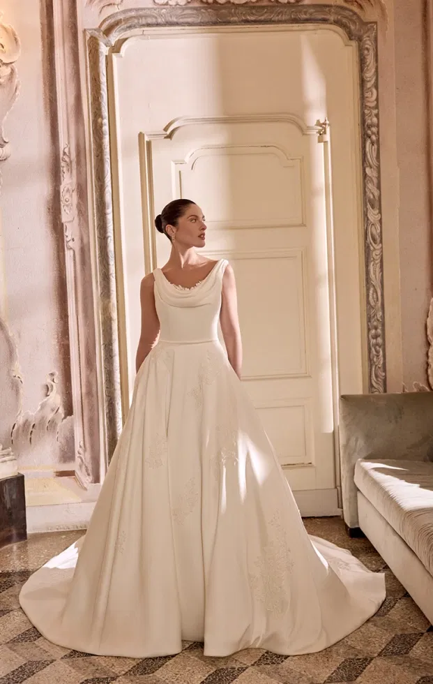 Klassisches A-Linien-Brautkleid mit weich fallendem Drapé-Ausschnitt und floralen Details auf dem Rock