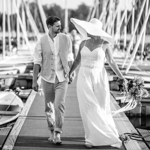 Brautpaar beim entspannten Spaziergang am Steg – romantisches Titelmotiv zum Interview über Heiraten in Düsseldorf.