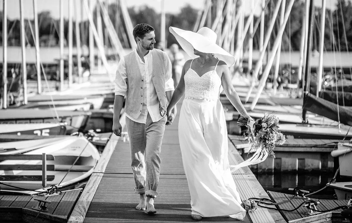 Brautpaar beim entspannten Spaziergang am Steg – romantisches Titelmotiv zum Interview über Heiraten in Düsseldorf.