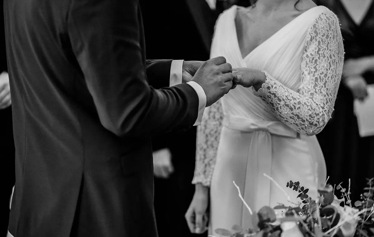 Schwarz-weiß-Aufnahme vom Ringtausch während einer freien Trauung – Braut und Bräutigam stecken sich während der Hochzeitszeremonie die Ringe an.