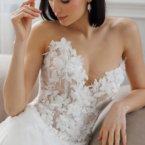 Brautkleid Detailaufnahme mit floraler 3D-Spitze und asymmetrischem One-Shoulder-Design für einen modernen, romantischen Look