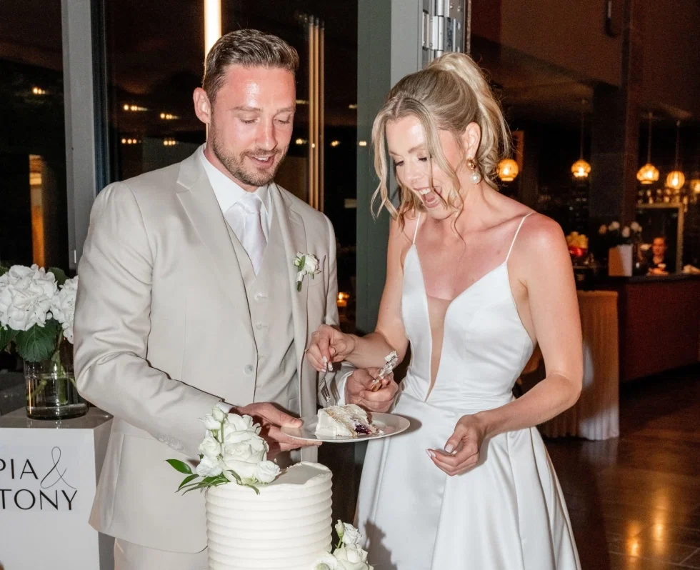 Pia und Tony schneiden ihre Hochzeitstorte an.